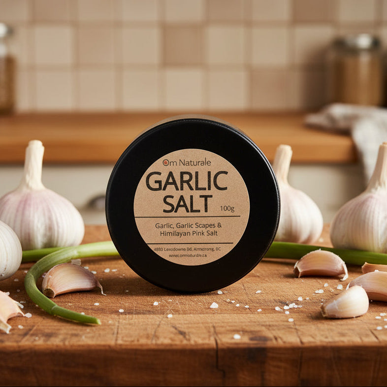 Garlic salt displayed with Omgrown garlic and scapes – natural Himalayan pink salt blend for deep savory punch, farmcrafted by Om Naturale.