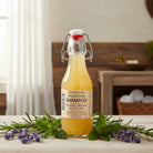 Nourishing shampoo displayed with Omgrown herbal infusions (lavender peppermint nettles chamomile) – natural soap-free cleanser with essential oils, eco refillable from Om Naturale farm.