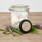Om Naturale Alpine 120-count compressed towel refill jar displayed with an Alpine Shower in a Tin and botanicals.