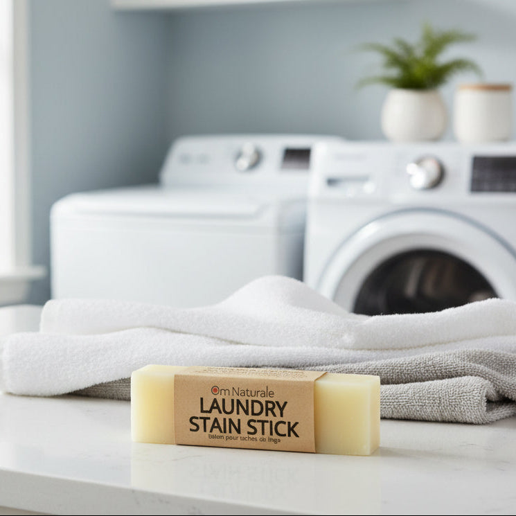 Om Naturale Laundry Stain Stick styled in laundry room setting with sustainable packaging, natural stain fighting essential oil bar