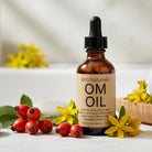 Om Oil displayed with wild rose hip and St. John's wort – natural multi-purpose oil with geranium patchouli ylang ylang vanilla aroma, Omgrown infusions from Om Naturale farm.