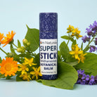 Close-up of Super Stick botanical balm –  compostable push tube revealing infused salve with calendula poplar St. John's Wort comfrey plantain violet, natural and unscented from Om Naturale farm.