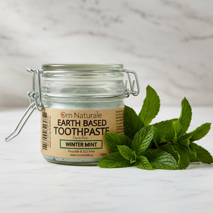 Wintermint natural toothpaste displayed with fresh mint leaves – fluoride-free glycerin-free SLS-free blend with organic coconut oil and calendula, refreshing daily care handmade by Om Naturale Armstrong BC.