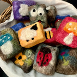 Handmade vegan wool felted soaps with bee, face, mushroom, flower, and ladybug patterns, crafted in Armstrong, BC

