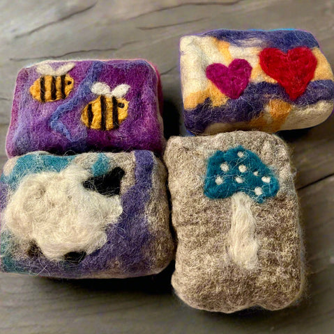 Handmade wool felted soaps with bee, heart, mushroom, and sheep patterns, crafted in Okanagan, BC.